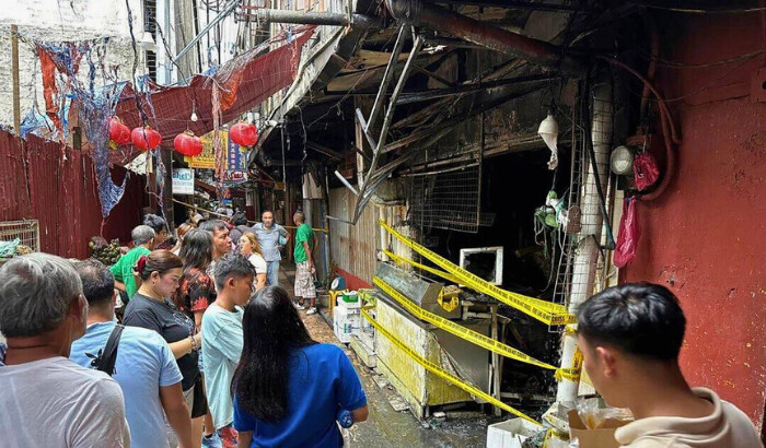 La gente se reúne cerca del lugar de un incendio en Manila el 2 de agosto de 2024. (Joeal Calupitan/AP Foto)