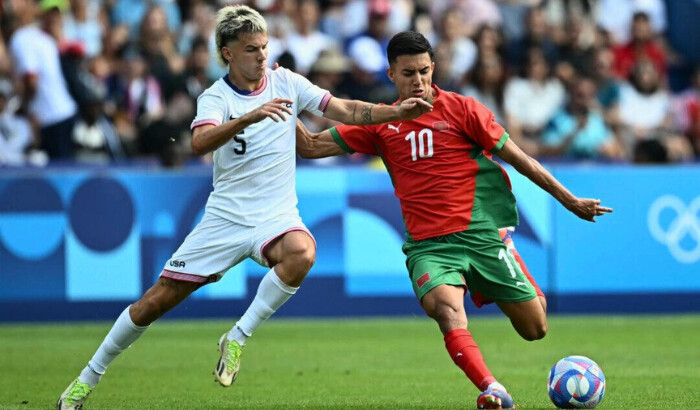 El delantero #10 de Marruecos, Ilias Akhomach (R), lucha por el balón con el defensa #05 de Estados Unidos, John Tolkin, durante el partido de fútbol masculino de cuartos de final entre Marruecos y Estados Unidos en los Juegos Olímpicos de París 2024 en el Parque de los Príncipes de París el 2 de agosto de 2024. (Paul Ellis/ AFP vía Getty Images)