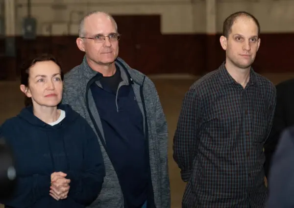 Los exprisioneros liberados por Rusia, el periodista estadounidense Evan Gershkovich (d), el exmarine estadounidense Paul Whelan (c) y la periodista ruso-estadounidense Alsu Kurmasheva (i), de pie tras aterrizar en la Base Conjunta San Antonio-Kelly Field, Texas, el 2 de agosto de 2024. (Suzanne Cordeiro/AFP vía Getty Images)