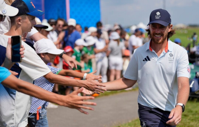 Tommy Fleetwood, de Gran Bretaña, da la mano a los aficionados mientras camina hacia el tee del hoyo 15 durante la segunda ronda de la prueba masculina de golf de los Juegos Olímpicos de Verano de 2024 en Saint-Quentin-en-Yvelines, Francia, el 2 de agosto de 2024. (George Walker IV/Foto AP)