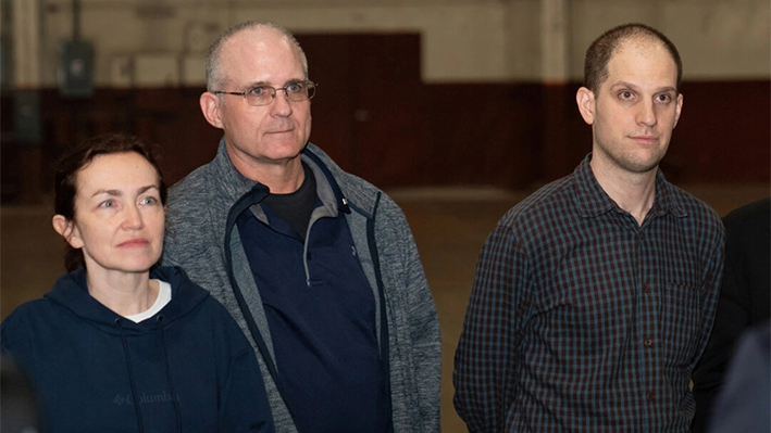 Los exprisioneros liberados por Rusia, el periodista estadounidense Evan Gershkovich (d), el exmarine estadounidense Paul Whelan (c) y la periodista ruso-estadounidense Alsu Kurmasheva (i), de pie tras aterrizar en la Base Conjunta San Antonio-Kelly Field, Texas, el 2 de agosto de 2024. (Suzanne Cordeiro/AFP vía Getty Images)
