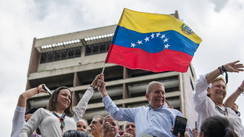 La líder opositora María Corina Machado y el candidato presidencial opositor Edmundo González ondean una bandera venezolana durante una protesta contra el fraude en las elecciones presidenciales el 30 de julio de 2024 en Caracas, Venezuela. (Foto de Alfredo Lasry R/Getty Images)