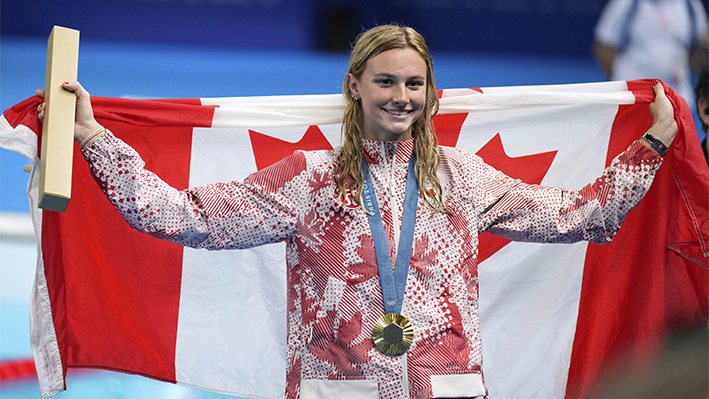 Summer McIntosh, de Canadá, celebra con la medalla de oro durante la ceremonia de entrega de premios de los 200 metros mariposa femenino en los Juegos Olímpicos de Verano de 2024 en Nanterre, Francia, el jueves 1 de agosto de 2024. (AP Photo/Ashley Landis)