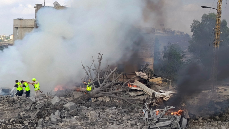 Trabajadores de la defensa civil libanesa rocían la tierra mientras arde un vehículo tras un ataque aéreo israelí contra la ciudad de Shamaa (Chamaa), en el sur de Líbano, el 1 de agosto de 2024, en medio de los continuos enfrentamientos transfronterizos entre tropas israelíes y terroristas de Hizbulá. (Kawnat Haju/AFP vía Getty Images)