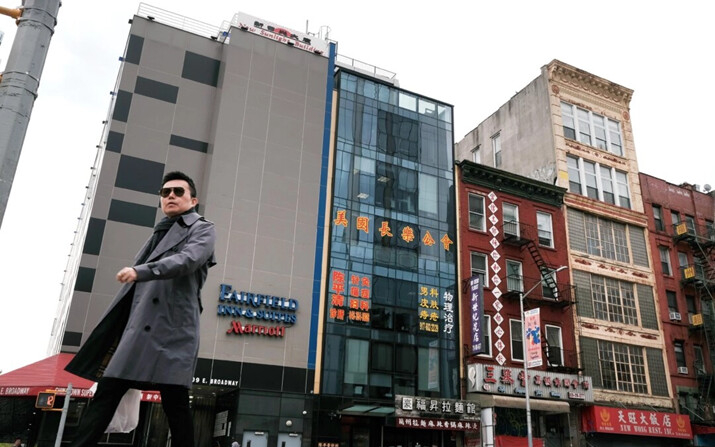 La gente pasa junto a un edificio (centro) usado presuntamente como una comisaría secreta de la policía china, en Chinatown, con el fin de reprimir a los disidentes que viven en Estados Unidos en nombre del Partido Comunista Chino, en el bajo Manhattan, el 18 de abril de 2023. (Spencer Platt/Getty Images)