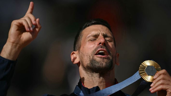 El medallista de oro, el serbio Novak Djokovic posa con su medalla en el podio durante la ceremonia de presentación de la prueba individual masculina de tenis en la pista Philippe-Chatrier del estadio Roland-Garros durante los Juegos Olímpicos de París 2024, en París, el 4 de agosto de 2024. (CARL DE SOUZA/AFP vía Getty Images)