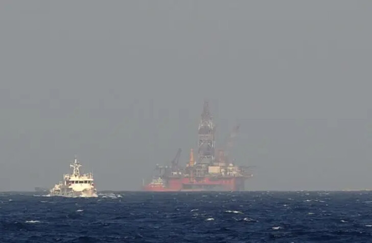 Un buque guardacostas vietnamita muestra un buque guardacostas chino (izq.) navegando cerca de una plataforma de perforación petrolera china en aguas en disputa en el Mar de China Meridional, el 14 de mayo de 2014. (Hoang Dinh Nam/AFP/Getty Images)