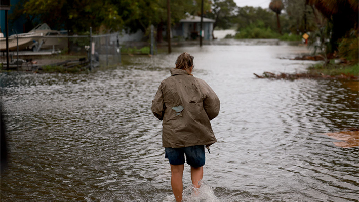 Una persona camina a través de una calle inundada causada por la lluvia y la marejada ciclónica del huracán Debby el 05 de agosto de 2024, en Cedar Key, Florida. (Joe Raedle/Getty Images)