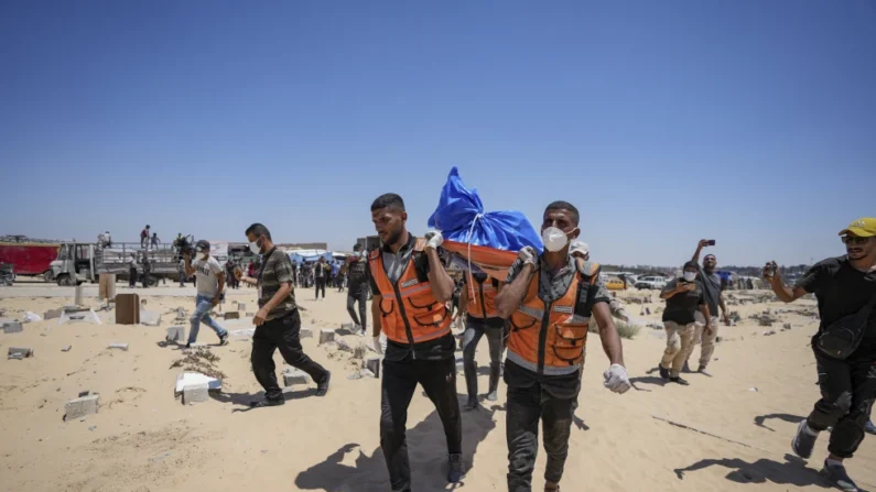 Operarios trasladan un cadáver devuelto por Israel a un cementerio en Jan Yunis, Gaza, el 5 de agosto de 2024. (AP Foto/Abdel Kareem Hana)
