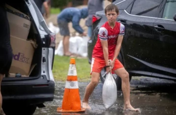 Brantley Schnabel ayuda a su familia a llevar sacos de arena a su furgoneta mientras se preparan para el huracán Debby en un parque del condado en Savannah, Georgia, el 5 de agosto de 2024. (Stephen B. Morton/Foto AP)