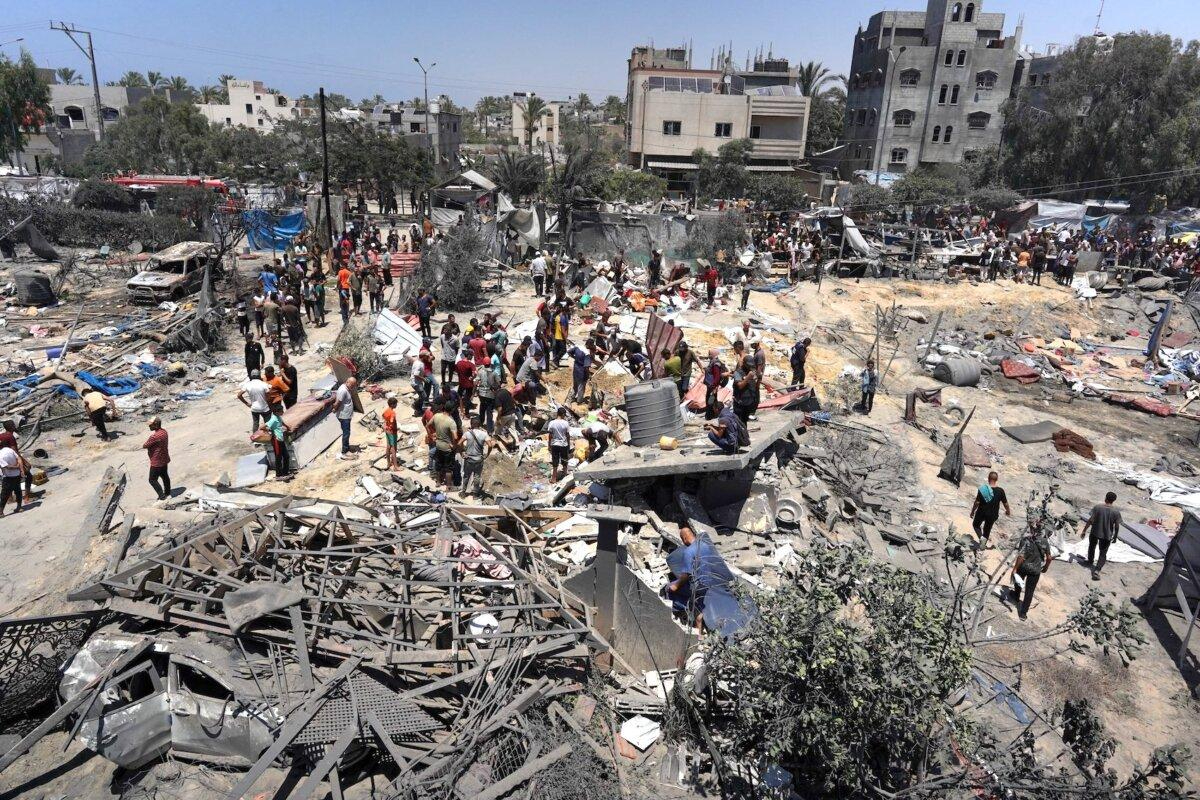 Gazatíes observan los escombros tras un ataque militar israelí cerca de la ciudad de Jan Yunis, en el sur de la Franja de Gaza, el 13 de julio de 2024. (Bashar Taleb/AFP vía Getty Images)