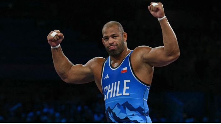 El chileno Yasmani Acosta Fernández celebra su victoria sobre el chino Meng Lingzhe en su combate de semifinales de lucha grecorromana masculina de 130 kg en el Champ-de-Mars Arena durante los Juegos Olímpicos de París 2024, en París, el 5 de agosto de 2024. (LUIS ROBAYO/AFP vía Getty Images)