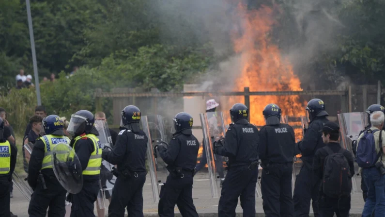 Oficiales de policía con manifestantes mientras estallan problemas durante una manifestación contra la inmigración frente al Holiday Inn Express en Rotherham, South Yorkshire, el 4 de agosto de 2024. (Danny Lawson/PA)