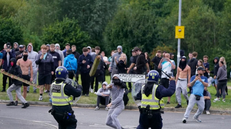 Un joven lanza un poste de la valla hacia la policía durante una manifestación contra la inmigración cerca del Holiday Inn Express en Rotherdam, Inglaterra, el 4 de agosto de 2024. (Danny Lawson/PA Wire)