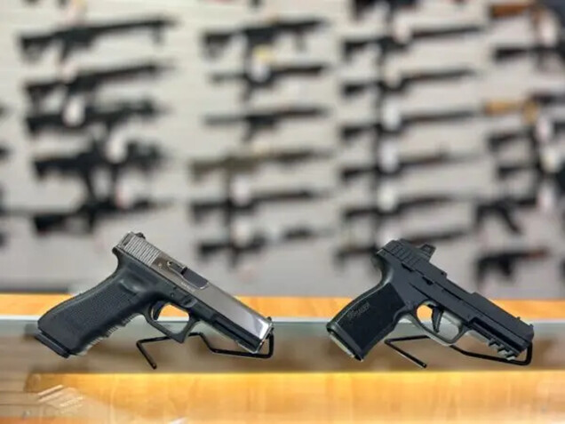 Una pistola Glock 17 de 9 mm (izq.) y una pistola Sig Sauer P322 calibre 22 en una mesada de vidrio frente a una pared de rifles, en Lawful Defense, en Gainesville, Florida, el 19 de abril de 2023. (Nanette Holt/The Epoch Times)