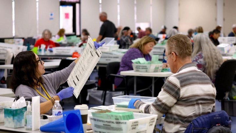 Un trabajador electoral inspecciona una papeleta de voto por correo en Phoenix el 6 de noviembre de 2022. (Justin Sullivan/Getty Images)