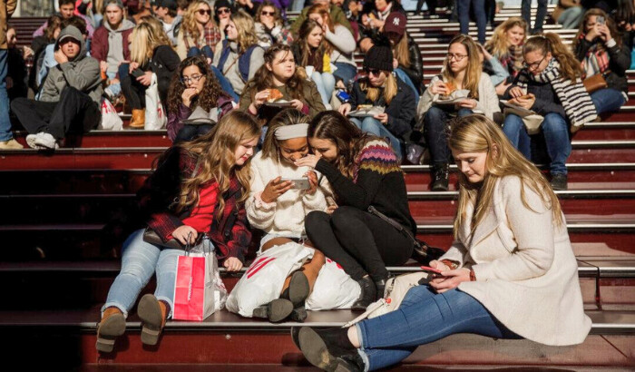 Un grupo de adolescentes mira una fotografía tomada con un teléfono inteligente en Times Square en la ciudad de Nueva York el 1 de diciembre de 2017. (Drew Angerer/Getty Images)