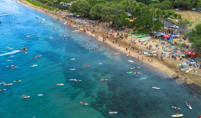 Vista aérea de surfistas y clubes de piragüismo remando en el parque Hanakaoʻo para conmemorar el primer aniversario del incendio forestal de Lahaina en Lahaina, Hawái, el 8 de agosto de 2024. (Mengshin Lin/AP Foto)