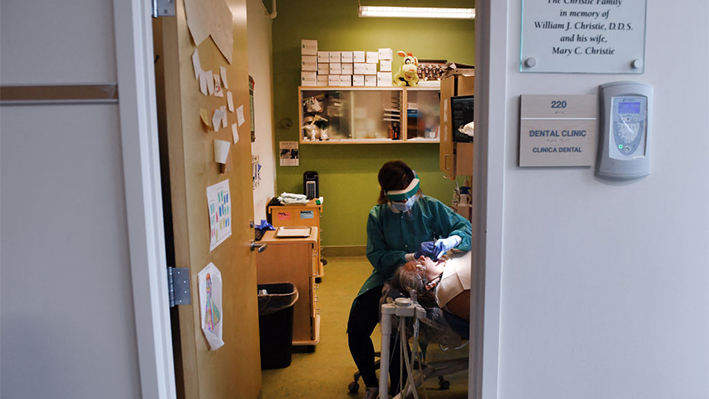 Chaina Cooper, higienista dental titulada, atiende a la paciente María A. Hernández, de 53 años, en la clínica dental de Bread for the City, una organización benéfica con sede en Washington que proporciona alimentos y servicios médicos gratuitos o a precio reducido a comunidades desfavorecidas, el 28 de octubre de 2021 en Washington, DC. (OLIVIER DOULIERY/AFP vía Getty Images)
