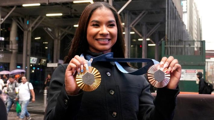 La gimnasta estadounidense Jordan Chiles muestra sus medallas después de tocar la campana de cierre en el Nasdaq MarketSite en Times Square de Nueva York, el 8 de agosto de 2024. (Richard Drew/Foto AP)