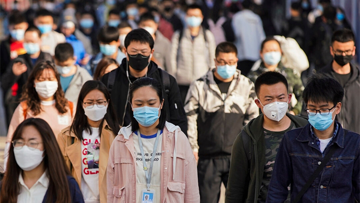 Los viajeros llevan mascarillas protectoras mientras salen de un tren en una estación de metro durante la hora punta en Beijing, China, el 13 de abril de 2020. (Lintao Zhang/Getty Images)