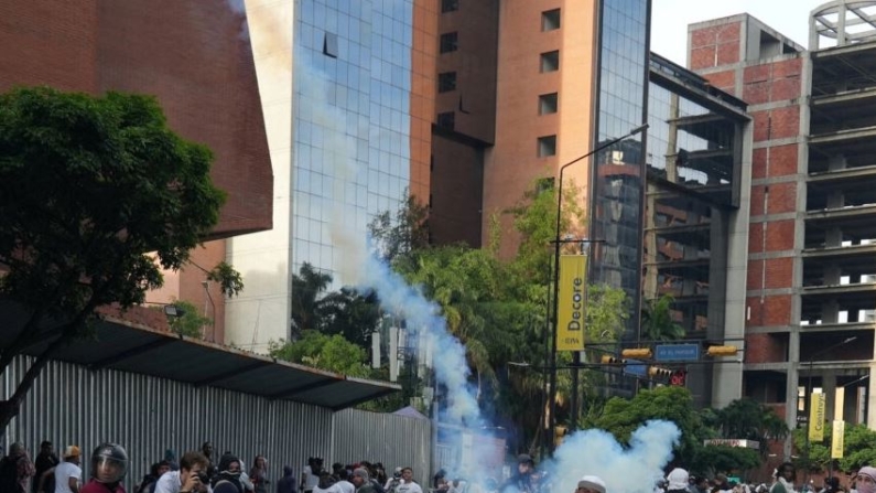 Un manifestante lanza hacia atrás un bote de gas lacrimógeno mientras partidarios de la oposición venezolana protestan en Caracas, Venezuela, el 29 de julio de 2024. (Reuters/Alexandre Meneghini)