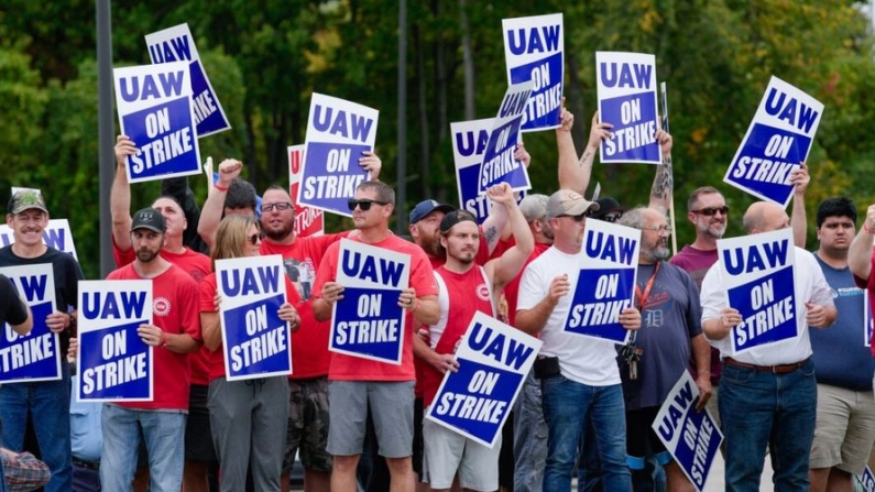 Miembros de United Auto Workers sostienen carteles de piquete cerca de una planta de ensamblaje de General Motors en Delta Township, Michigan, el 29 de septiembre de 2023. (Paul Sancya/AP Photo)