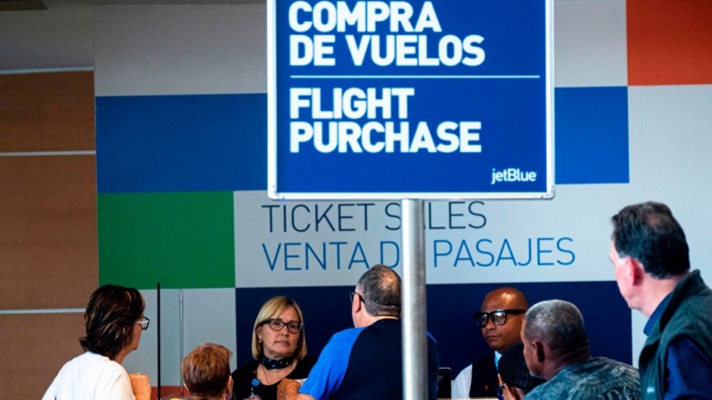 La gente compra billetes de avión en un mostrador de JetBlue en el aeropuerto internacional Luis Muñoz Marín en San Juan, Puerto Rico, el 14 de marzo de 2020. (Ricardo Arduengo/AFP vía Getty Images)