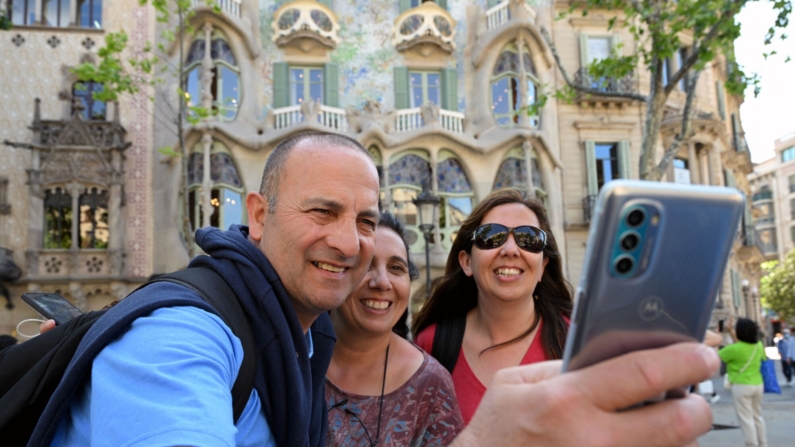 Turistas se toman una foto selfie con su teléfono móvil frente a la Casa Batlló del arquitecto catalán Antoni Gaudí en Barcelona, el 11 de mayo de 2022.  (Foto de LLUIS GENE/AFP vía Getty Images)