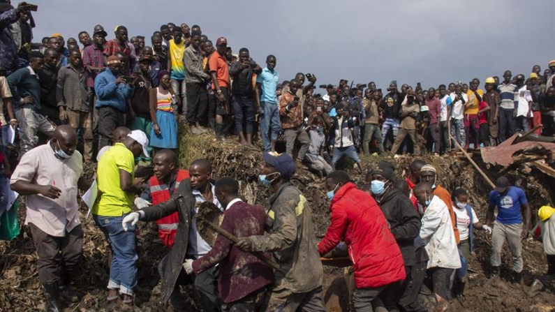 Varias personas llevan a un superviviente a un lugar seguro durante las labores de rescate después de que un deslizamiento de tierra sepultara casas en un vertedero en el distrito de Kiteezi, Kampala, Uganda, el 10 de agosto de 2024. EFE/Isaac Kasamani