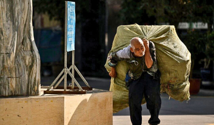 Un anciano lleva una bolsa de materiales reciclables a la espalda en Ruili, provincia occidental de Yunnan, en China, el 13 de enero de 2023. (Noel Celis/AFP vía Getty Images)