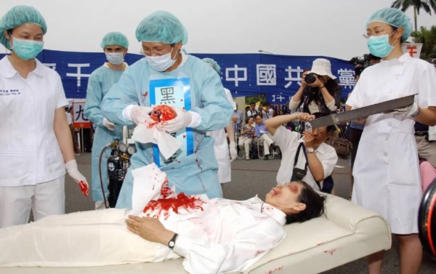 Practicantes de Falun Gong durante una representación de la práctica del Partido Comunista Chino de la sustracción forzada de órganos durante una manifestación en Taipei, Taiwán, el 23 de abril de 2006. (Patrick Lin/AFP vía Getty Images)