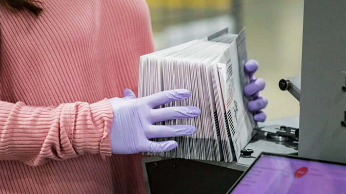 Un trabajador electoral sostiene boletas en Pomona, California, en una fotografía de archivo. (John Fredricks/The Epoch Times)
