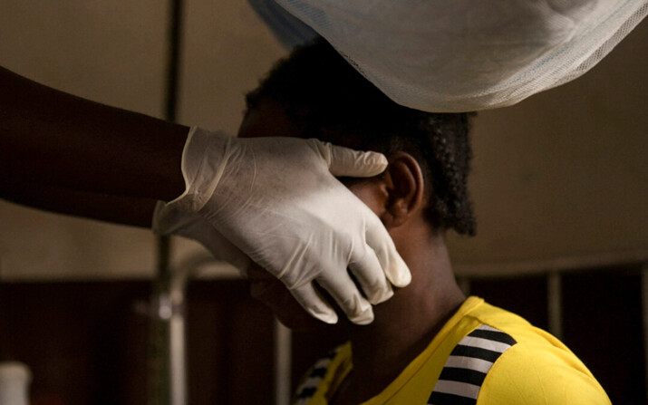 Un médico examina a una mujer infectada con viruela del mono en Zomea Kaka, en la República Centroafricana, el 18 de octubre de 2018. (Charles Bouessel/AFP/Getty Images)
