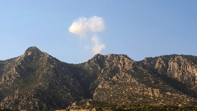 Una columna de humo se eleva sobre las montañas de Matin (Jabal Matin), cerca de la frontera con Turquía, después de un supuesto ataque aéreo turco, el 23 de julio de 2023. (AFP vía Getty Images)