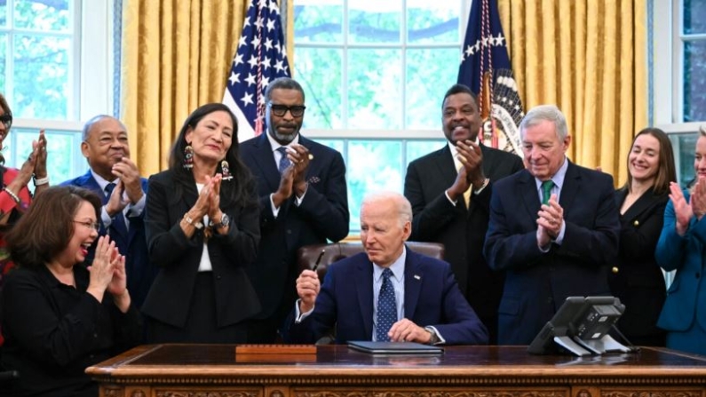 El presidente Joe Biden, junto con líderes de los derechos civiles, miembros de la comunidad y funcionarios electos, firma una proclamación para designar el Monumento Nacional al Disturbio Racial de Springfield de 1908, en el Despacho Oval de la Casa Blanca en Washington, el 16 de agosto de 2024. (Andrew Caballero-Reynolds/AFP vía Getty Images)