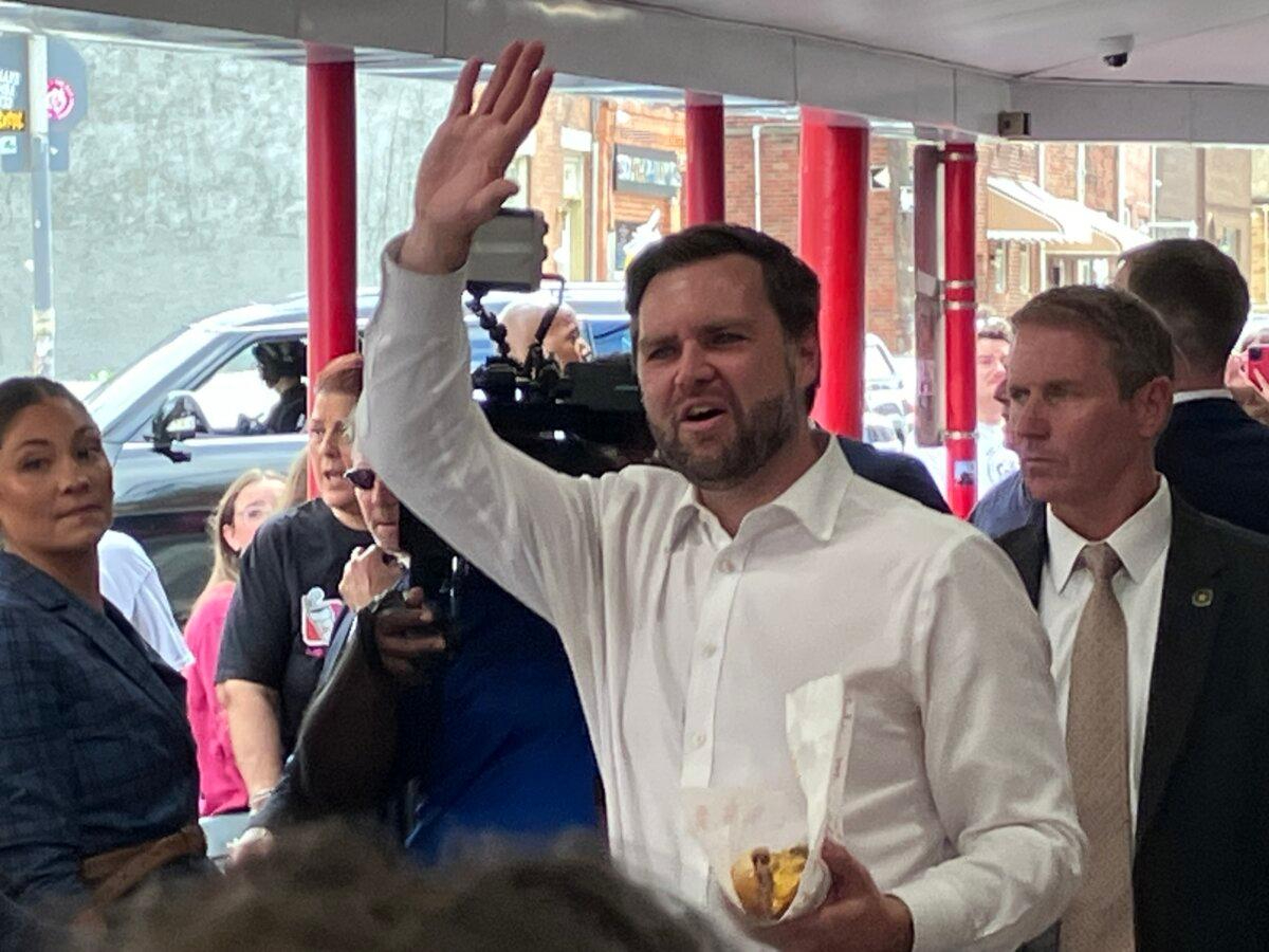 El candidato republicano a la vicepresidencia, el senador JD Vance (R-Ohio), saluda a la gente mientras sostiene un sándwich de cheesesteak del restaurante Pat's King of Steaks en Filadelfia, Pensilvania, el 19 de agosto de 2024. Janice Hisle/The Epoch Times