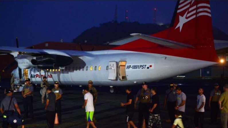 Colombianos caminan esposados y con grilletes hacia un avión para su deportación en el aeropuerto Marcos A. Gelabert de Albrook en Ciudad de Panamá, Panamá, el 20 de agosto de 2024. (Agustin Herrera/AP Photo)