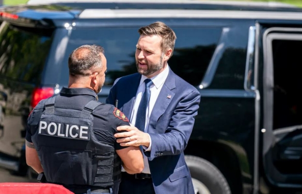 El candidato republicano a la vicepresidencia, el senador republicano por Ohio, J.D. Vance, saluda a un agente de policía antes de un mitin de campaña en Kenosha, Wisconsin, el 20 de agosto de 2024. (Andy Manis/Getty Images)