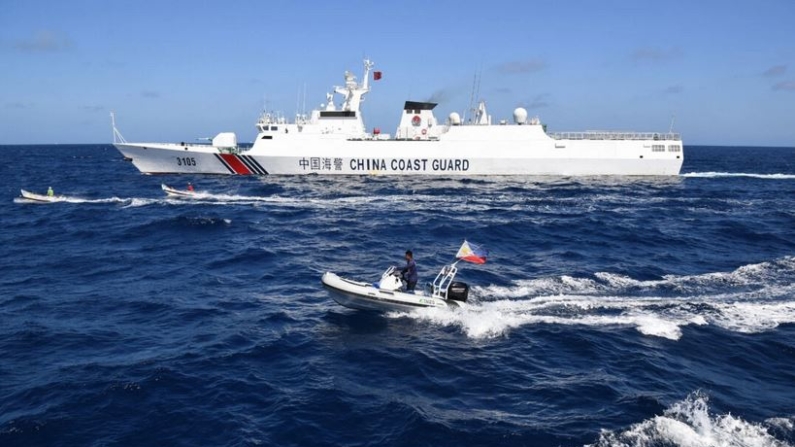 Un barco guardacostas chino (arriba) navega peligrosamente cerca de pescadores filipinos a bordo de dos botes de madera (centro), mientras un bote inflable de Pesca y Recursos Acuáticos de Filipinas observa, cerca del banco de arena Scarborough , en el Mar de China Meridional, el 16 de febrero de 2024. (Ted Aljibe/ AFP/Getty Images)