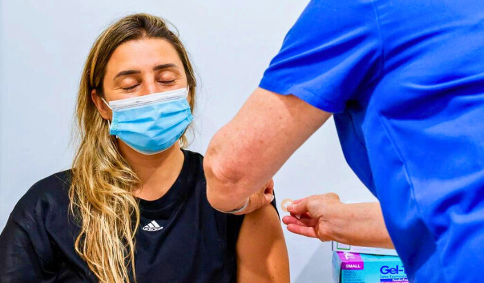 Una mujer cierra los ojos mientras recibe una vacuna contra el COVID-19 en el consultorio médico familiar de Sydney Road, en Sídney, Australia, el 10 de enero de 2022. (Jenny Evans/Getty Images)