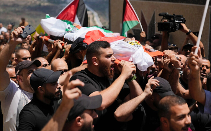 Dolientes llevan el cuerpo del palestino Rasheed Mahmoud Sadah, de 23 años, durante su funeral en la aldea cisjordana de Jit, cerca de Nablus, el viernes 16 de agosto de 2024. (Nasser Nasser/AP Photo)