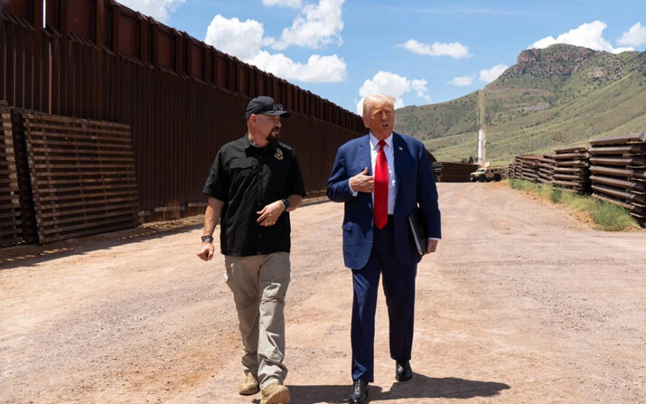 El expresidente Donald Trump camina con el miembro de la junta directiva del Consejo Nacional de Patrulla Fronteriza, Art Del Cueto, a lo largo de la frontera entre Estados Unidos y México al sur de Sierra Vista, Arizona, el 22 de agosto de 2024. (Rebecca Noble/Getty Images)