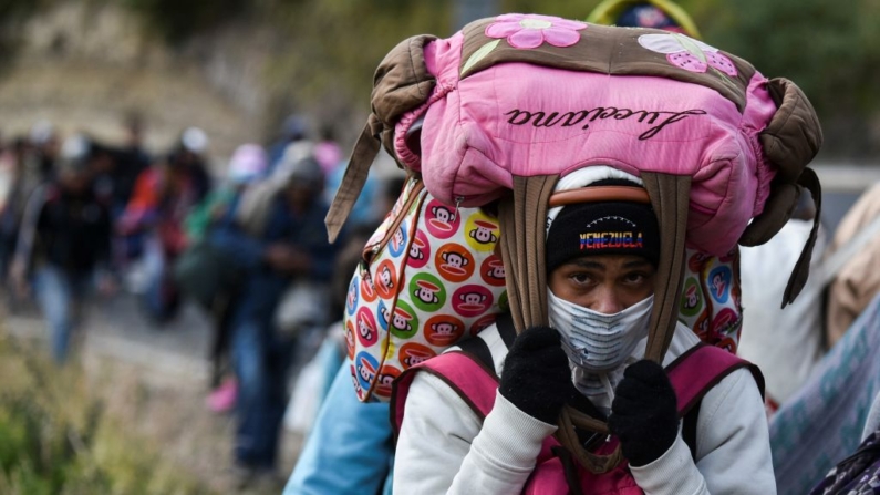 Una mujer migrante venezolana que se dirige a Perú lleva bolsas mientras camina por la carretera Panamericana en Tulcán, Ecuador, después de cruzar desde Colombia, el 21 de agosto de 2018. (Luis Robayo/AFP vía Getty Images)