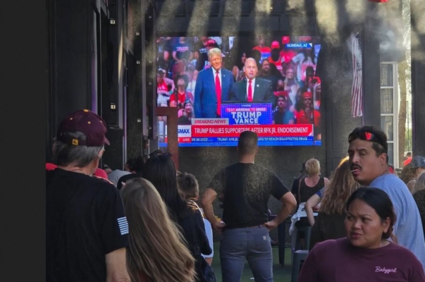 Simpatizantes de Trump observan al expresidente en un amplio televisor durante un mitin en Glendale, Arizona, el 23 de agosto de 2024. (Allan Stein/The Epoch Times)