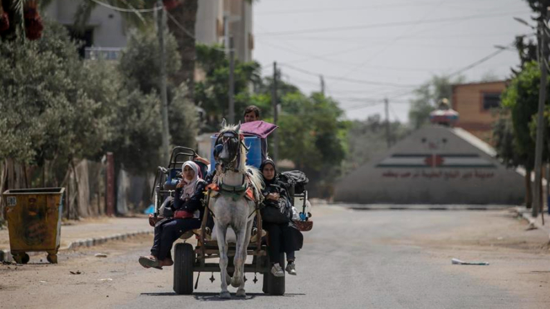 Palestinos desplazados acarrean sus pertenencias en Deir Al Balah. EFE/EPA/Mohammed Saber