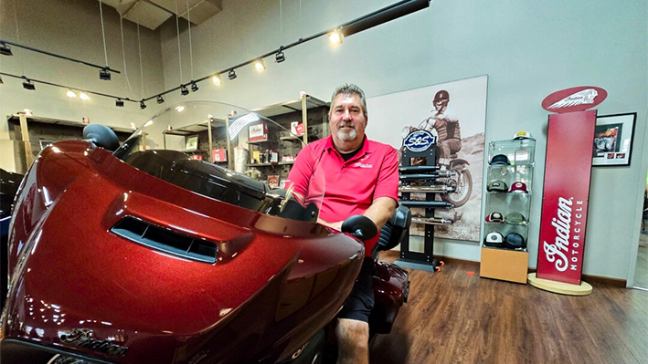 Quinn Keefe, director de marketing de Indian Motorcycle Peoria, sentado en un Scout, uno de los modelos más populares del concesionario, en Peoria, Arizona, el 21 de agosto de 2024. (Allan Stein/The Epoch Times)
