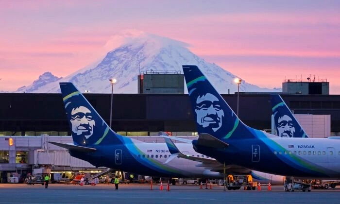 Aviones de Alaska Airlines estacionados en las puertas con el monte Rainier de fondo al amanecer, en el Aeropuerto Internacional de Seattle-Tacoma en Seattle el 1 de marzo de 2021. (Ted S. Warren/AP Photo)