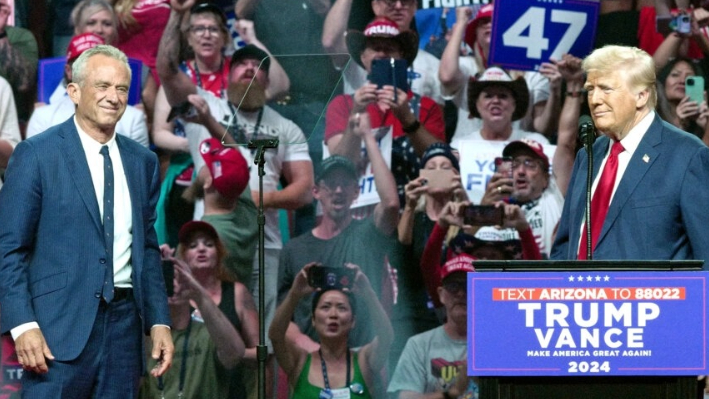 El expresidente y candidato presidencial republicano Donald Trump (d) recibe en el escenario al candidato presidencial independiente Robert F. Kennedy Jr (i) durante un mitin de campaña en el Desert Diamond Arena de Glendale, Arizona, el 23 de agosto de 2024. (Olivier Touron/AFP vía Getty Images)