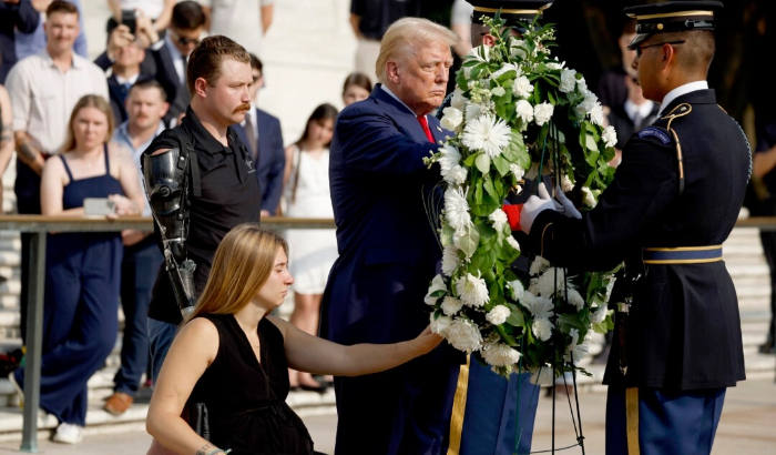 El expresidente Donald Trump deposita una corona de flores junto al cabo de la Infantería de Marina Kelsee Lainhart y el sargento de la Infantería de Marina Tyler Vargas-Andrews (al fondo), quienes resultaron heridos en el atentado del puerto de entrada Abbey, durante una ceremonia de colocación de coronas en la Tumba del Soldado Desconocido en el Cementerio Nacional de Arlington, en Arlington, Virginia, el 26 de agosto de 2024. (Anna Moneymaker/Getty Images)